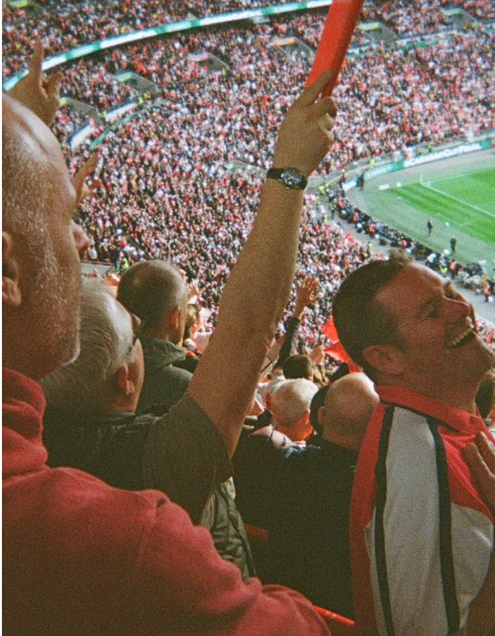 Football fans cheering in a packed stadium, from Peyto’s launch artwork